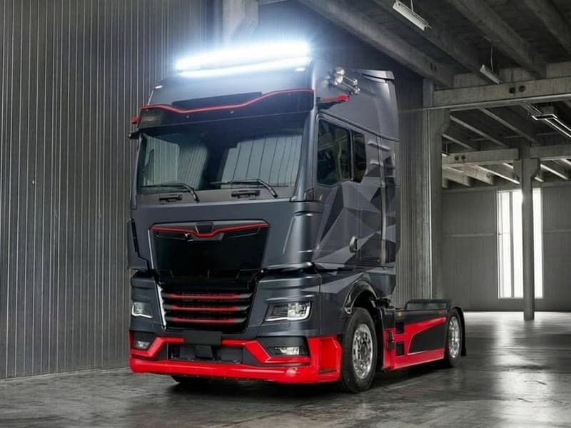 Camion Volvo gris et rouge stationné dans un hangar équipé d'une barre LED 24V incurvée allumée Next-Tech