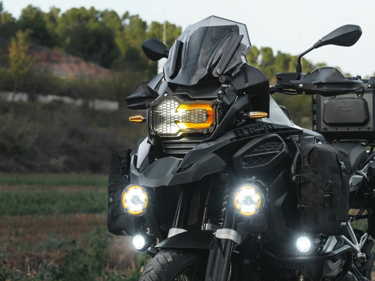 Phares additionnels LED allumés sur moto trail dans un garage, éclairage longue portée haute puissance