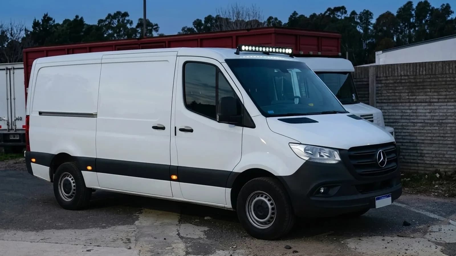 Barre LED Next-Tech allumée sur le toit d'un Mercedes Sprinter au crépuscule