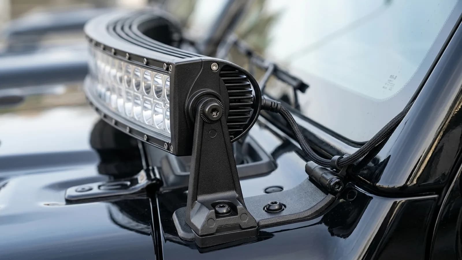 Détail de l'équerre de fixation d'une barre LED Next-Tech au pied du pare-brise d'une Jeep Wrangler