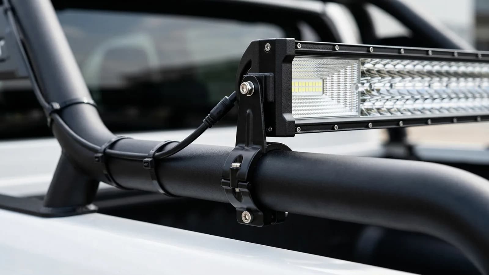 Détail de la fixation d'une barre LED Next-Tech sur le roll-bar de benne d'un Toyota Hilux