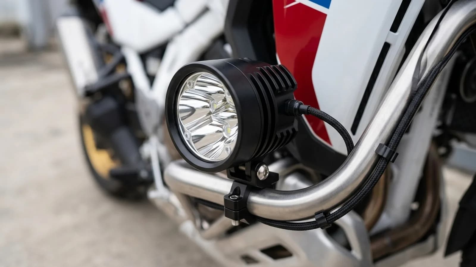 Détail du collier de fixation d'un feu additionnel LED Next-Tech sur le crash bar de la Honda Africa Twin