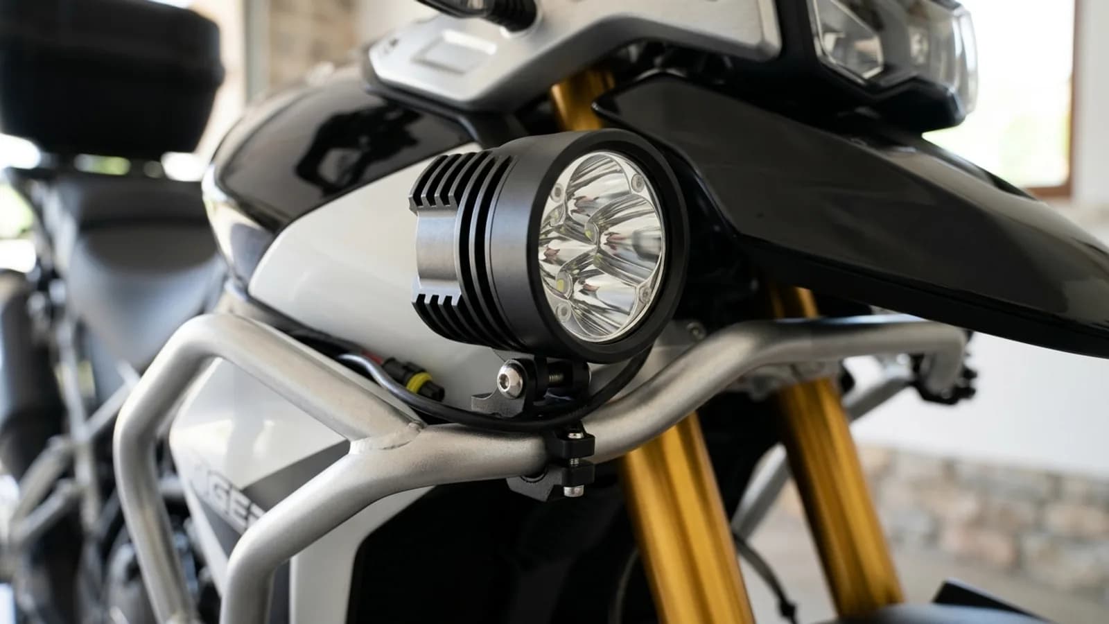 Détail du collier de fixation d'un feu additionnel LED Next-Tech sur le crash bar de la Triumph Tiger 900