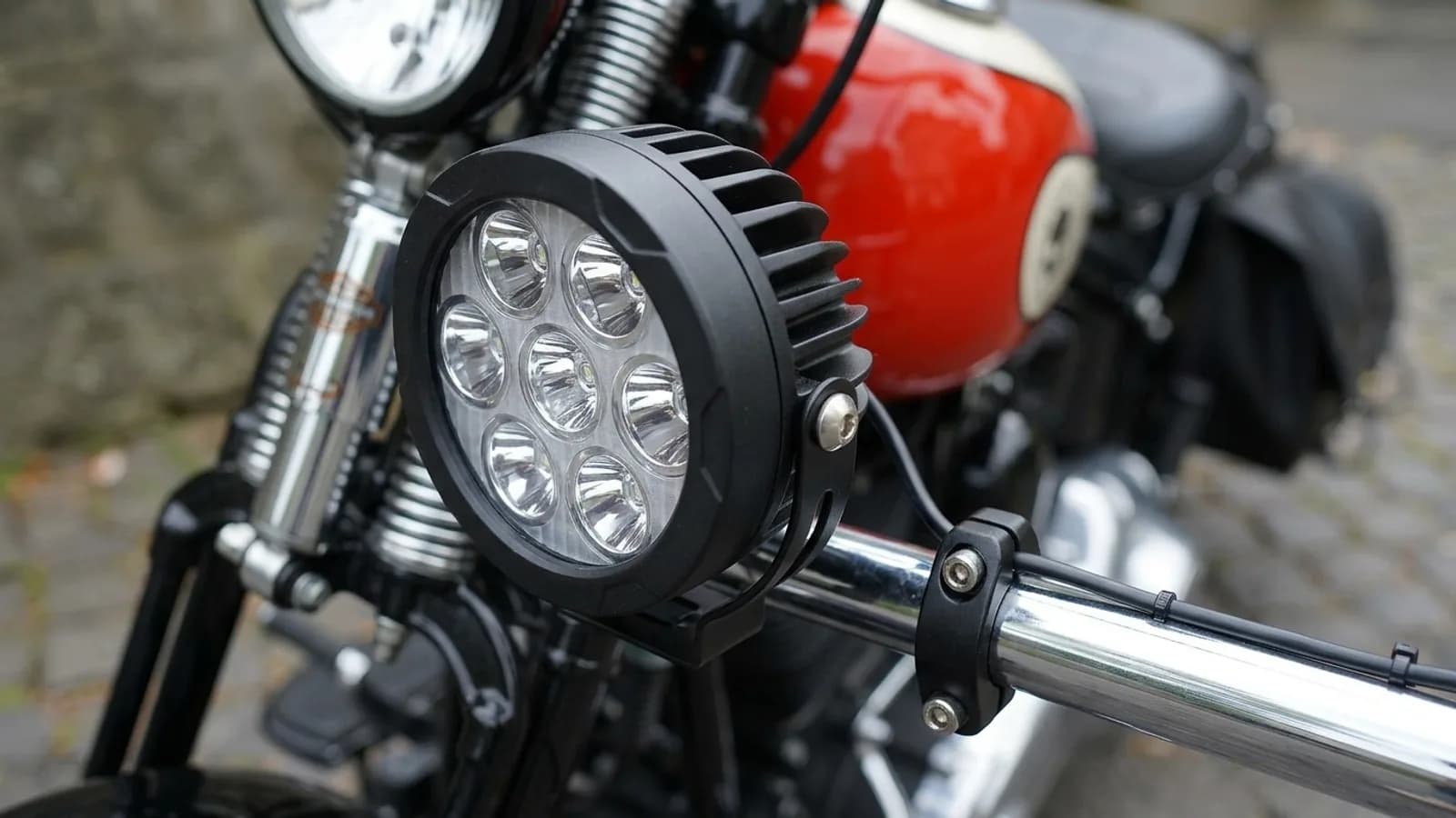 Détail de la fixation d'un phare additionnel LED Next-Tech sur la barre de passing lamps d'une Harley-Davidson