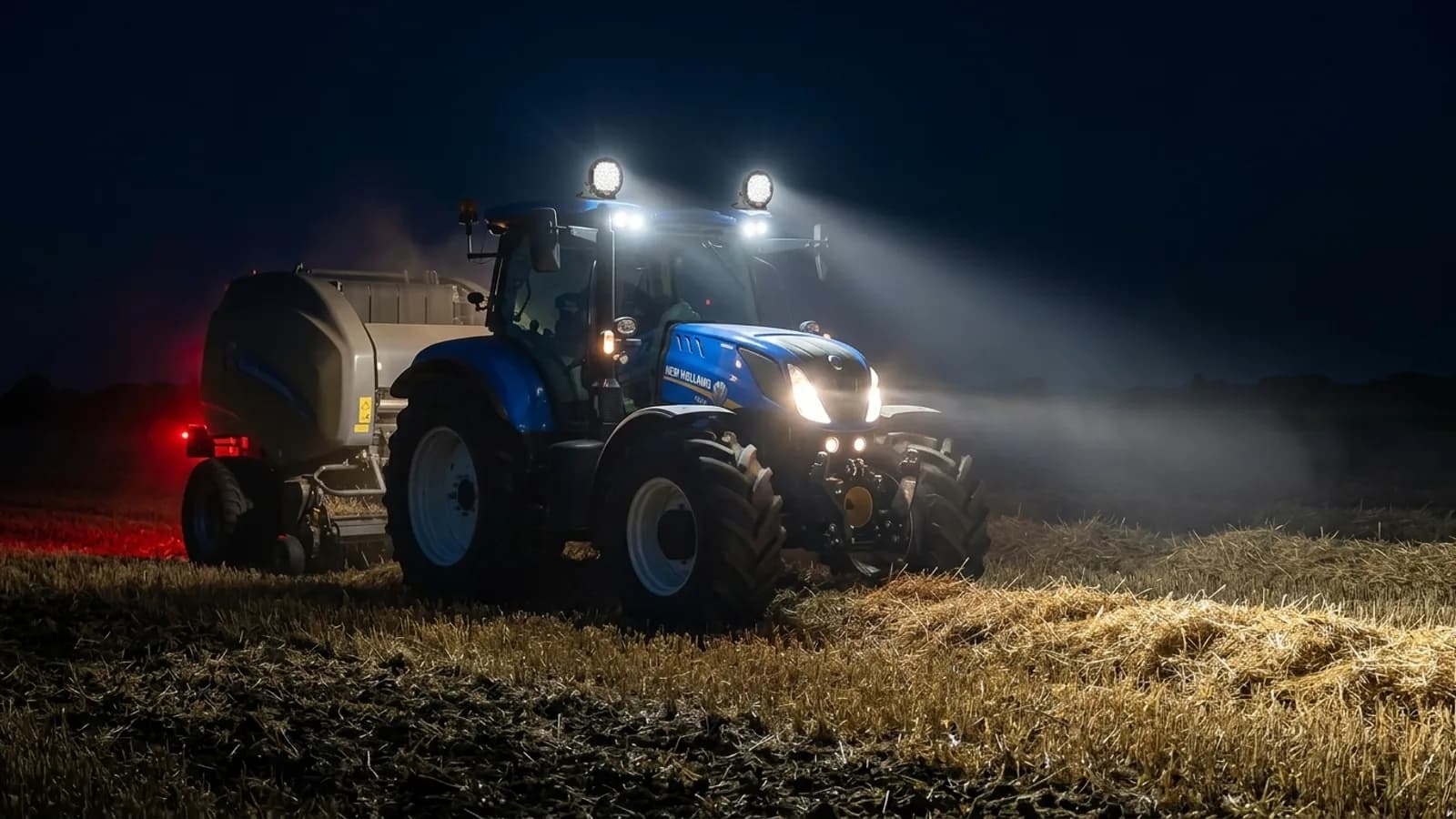 Tracteur New Holland pressant la paille de nuit, phares LED 185W Next-Tech allumés sur le toit