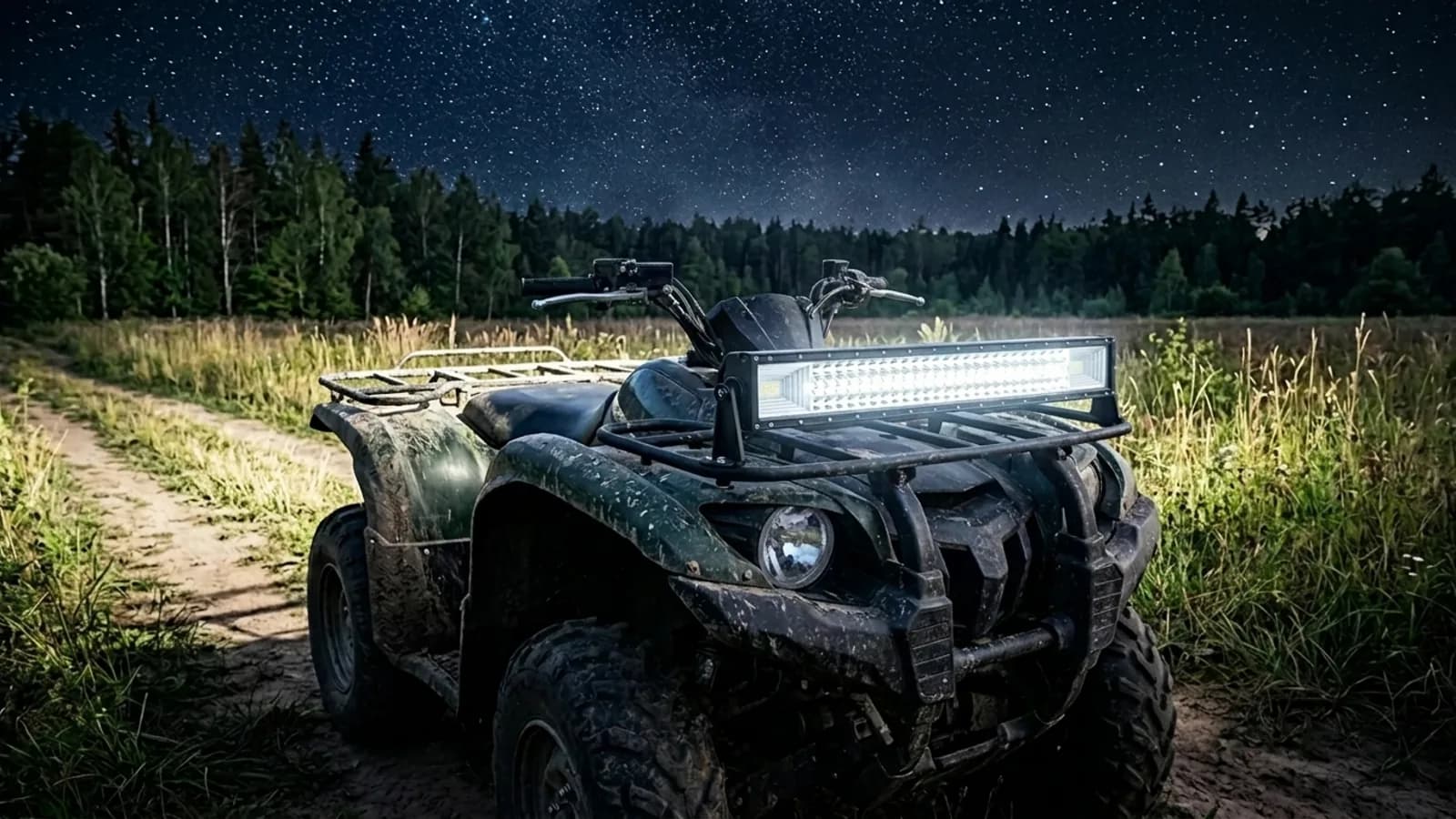 Quad utilitaire éclairant un champ en lisière de forêt la nuit avec sa barre LED et ses feux additionnels Next-Tech
