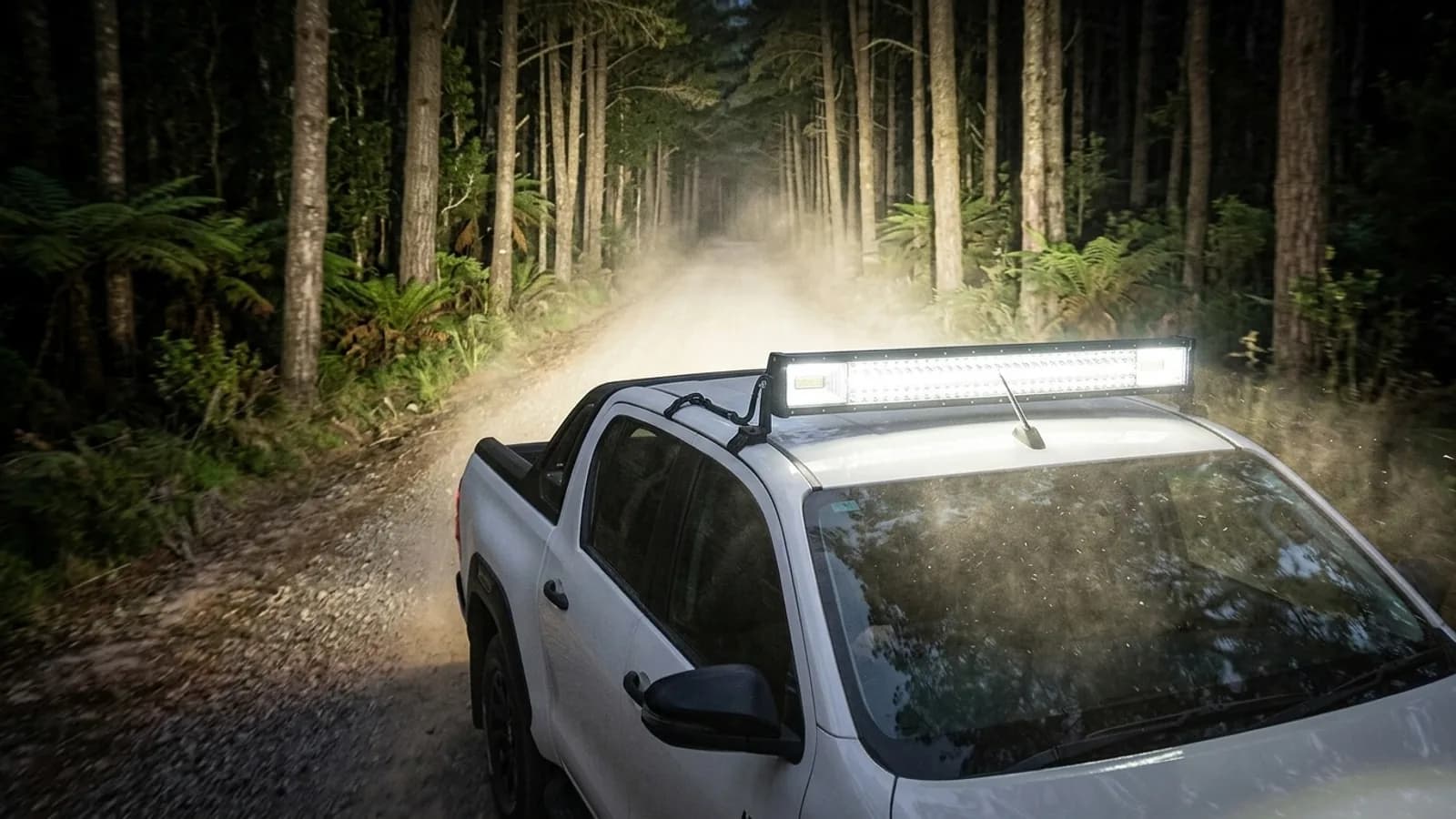 Toyota Hilux Invincible sur piste de nuit, barre LED triple rangée Next-Tech allumée sur le toit