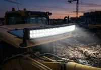 Barre LED incurvée Next‑Tech 55cm 120W allumée en blanc, montée sur engin de chantier au crépuscule