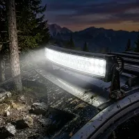 barre LED incurvée Next‑Tech 180w 80cm 13000 lumens allumée sur galerie de 4x4 boueux en forêt de montagne