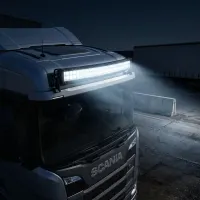 barre LED incurvée Next‑Tech 180w 80cm 13000 lumens allumée sur cabine de camion Scania de nuit en zone logistique