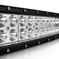 Gros plan sur les optiques chromées d'une barre LED incurvée Next‑Tech 180W éteinte, vue trois quarts sur fond studio blanc