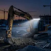 Pelleteuse sur chantier au crépuscule avec barre LED incurvée Next‑Tech 80cm allumée en blanc, vue de trois quarts
