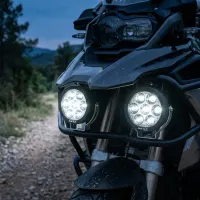 kit de feux LED longue portée ronds XP7 Next‑Tech 140w 18800 lumens 5000K allumés sur moto trail en chemin au crépuscule