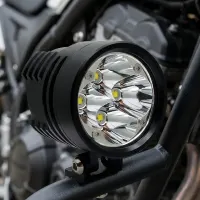 Phare LED Next‑Tech XP4 monté sur pare-cylindre crash bars de moto, gros plan optique chromée