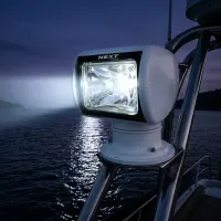 phare LED de recherche motorisé 360° Next‑Tech 120w 12500lm allumé sur yacht au crépuscule en mer