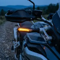 Clignotant LED séquentiel Next‑Tech allumé en orange sur une moto BMW au crépuscule en tout-terrain