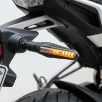 Clignotant LED séquentiel Next‑Tech allumé en orange sur l'arrière d'une moto, vu en gros plan