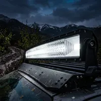 Gros plan sur la barre LED incurvée 720w Next‑Tech allumée blanc pur sur galerie de 4x4, faisceau combo puissant devant montagnes enneigées