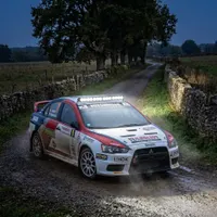 mitsubishi lancer evo de rallye en 3/4 avant sur chemin de campagne au crépuscule, barre LED 180w Next‑Tech allumée blanc pur