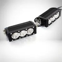 pack 2 rampes LED Next‑Tech pour rallye vues de 3/4 sur fond studio blanc, boîtiers alu noir et optiques à triple lentille