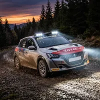 peugeot 208 rallye de 3/4 avant en dérapage sur piste boueuse au crépuscule équipée de rampes LED Next‑Tech allumées
