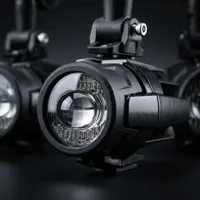 gros plan sur un phare additionnel LED antibrouillard Next‑Tech pour moto avec optique à lentille et fixation guidon sur fond studio noir