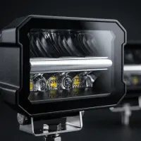 gros plan sur phare LED longue portée Next‑Tech avec marquage homologation E9 12V/24V et double DRL blanc et orange allumé