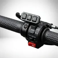 gros plan sur commodo guidon moto avec commande LED Next‑Tech, boutons phare, feux de route Hi/Lo, klaxon rouge et clignotants