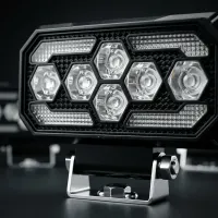 gros plan sur les optiques hexagonales d'un phare de travail LED Next‑Tech rectangulaire sur fond studio noir