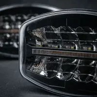 gros plan sur l'optique rectangulaire d'un phare LED additionnel 120W Next‑Tech pour camion, lentilles claires éteintes sur fond noir